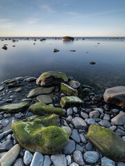 Coastal rocks covered in green algae in calm sea
