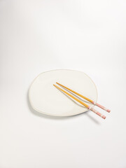 Minimalist Composition of White Plate and Chopsticks on a White Background