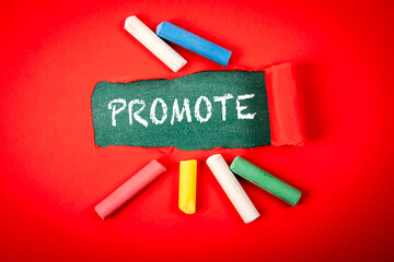 Promote Concept with Chalk on Chalkboard and Colorful Crayons