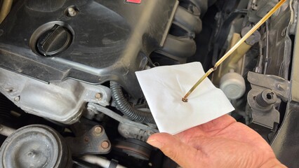 Mechanic man checking engine oil refill car maintenance close up engine.Car lubricator check