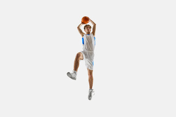 Focused player captured in high leap holds ball overhead ready to strike, full intensity in motion against white background. Concept of sport championship, tournament, game, training. Ad