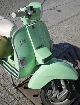 Light green LML Star vintage scooter parked on cobblestone street