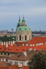 Obraz premium Close-up view at the dome of St.Nicholas Church surrounded by tiled red roofs.Mala Strana,Prague,Czech Republic 