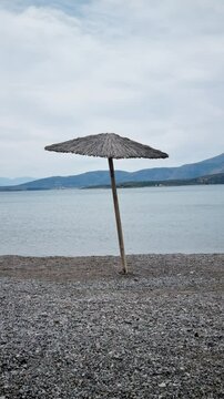 Beach Umbrella Swaying in the Wind on a Sunny Shore