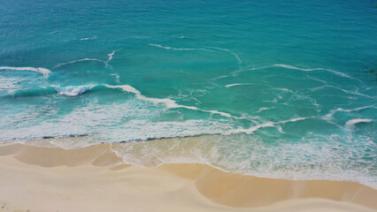 Aerial shot of a beach with ocean in the background, ideal for travel or nature-related uses