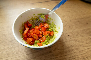 Mixing guacamole with cherry tomatoes