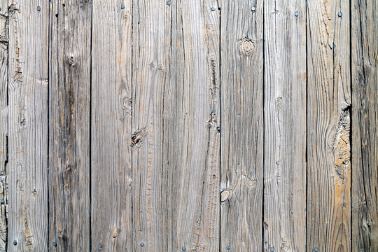 Old weathered gray wood surface with irregularities and signs of aging.