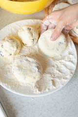 Caucasian hands making cottage cheese pancakes with raisins