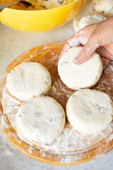 Caucasian hands making cottage cheese pancakes with raisins
