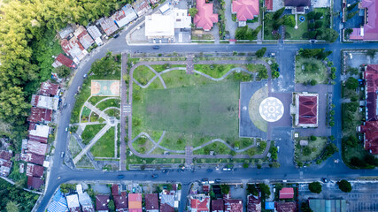 An aerial perspective of Taman Kartini in Bajawa, Flores. The park features a central green field,...