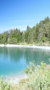 Lush alpine nature meets turquoise waters at Urisee lake in Tirol, peaceful retreat with green hills and blue sky reflections