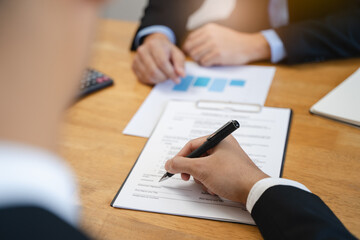 businessman sitting at desk holds pen signing contract paper, lease mortgage, employment hr or...