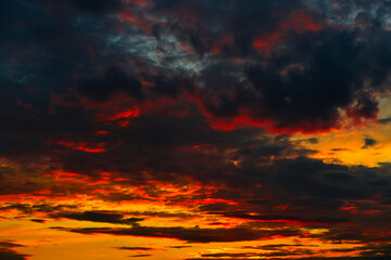 Orange, red and black clouds in the sunset sky before the storm