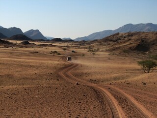 Dirt Road Through Arid dry South african Landscape with Distant Mountains Under Clear Blue Sky