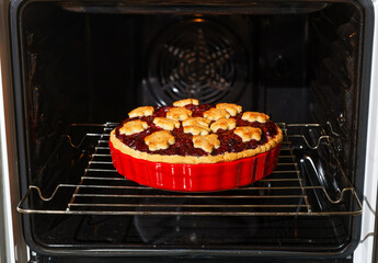 Closeup homemade berry pie baked in a home oven. Shallow focus.