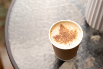 Street coffee with maple leaf pattern on foam on cafe table, autumn, copy space
