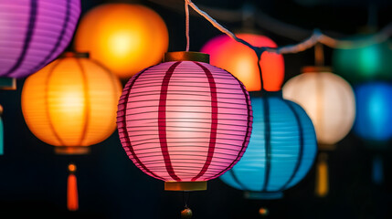 Fototapeta premium Colorful paper lanterns glowing at night during a festive