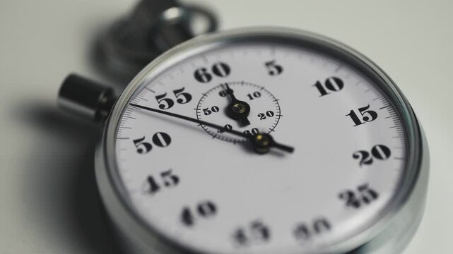 Close-up of a classic analog stopwatch counting seconds in real time. Precision timing concept symbolizing speed, accuracy, deadlines, time management in sports, business, or productivity contexts. 