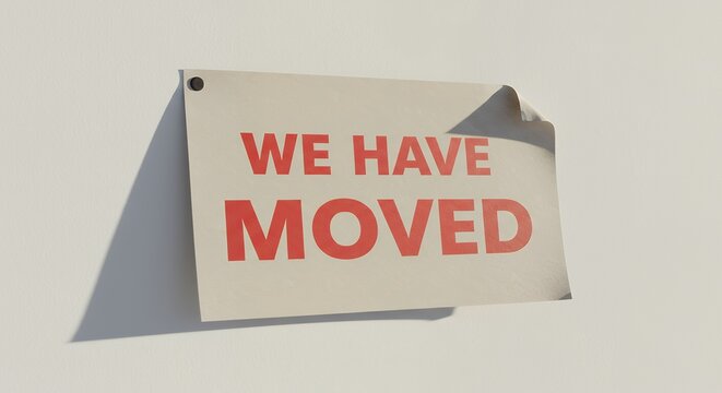 Sign saying We Have Moved on wall