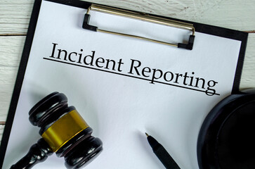 Incident Reporting text on white paper clipboard with gavel. Incident reporting concept