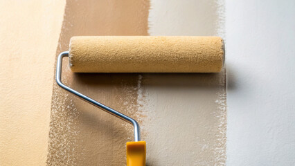 Obraz premium Closeup of paint roller applying eggshell finish on wall with beige and white colors showing texture and smooth coverage