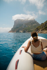 Tourist enjoying breathtaking view of sardinian coastline from a boat near baunei