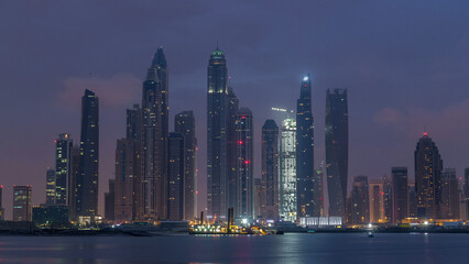 Obraz premium Panorama of modern skyscrapers in Dubai city night to day timelapse from the Palm Jumeirah Island.