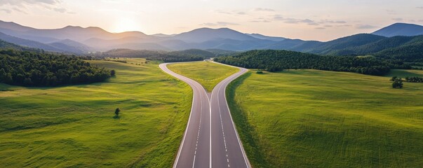 Construction infrastructure highway blueprint concept. Expansive road splits through lush green landscape and mountains.