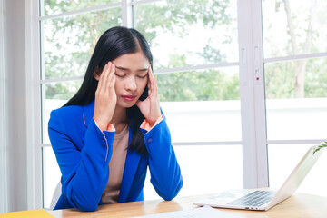 Fototapeta premium Asian businesswoman communicating with clients online using laptop in professional working environment. She is confident and articulate, demonstrating her skills in virtual communication.