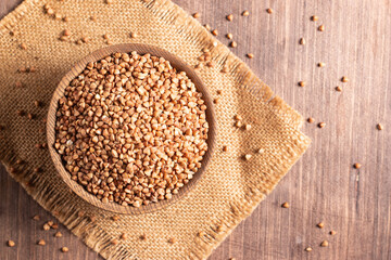 Buckwheat groats on wooden background. Healthy cereal concept.  