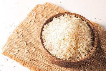 Uncooked white rice in a wooden bowl. Healthy cereal concept