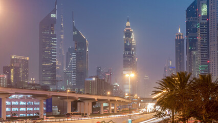 Fototapeta premium Traffic on intersection and bridge at the Sheikh Zayed Road day to night timelapse