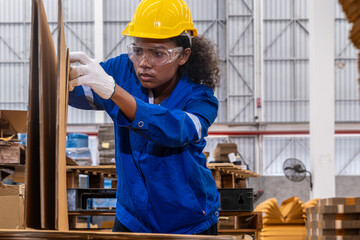African american engineer woman wearing safety helmet and vest working with card box in paper warehouse Products and corrugated cardboard Factory female worker in the manufacture of paper