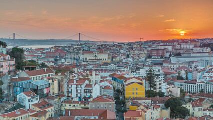 Lisbon at sunset aerial panoramic view of city centre with red roofs at autumn evening timelapse, Portugal