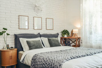 Stylish interior of bedroom with big comfortable grey bed