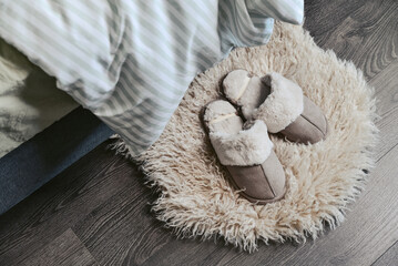 Female soft slippers on faux fur rug