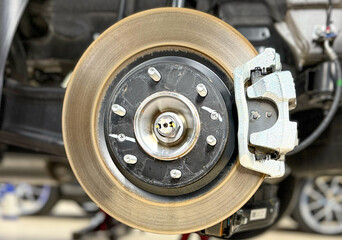 Car brake disc with grey caliper. Modern brake disc with holes and cooling. Brake disc and wheel...