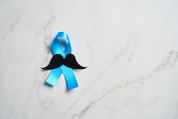 Blue ribbon with mustache supporting prostate cancer awareness month and men's health