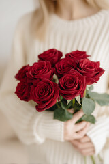Obraz premium Romantic Red Roses Held by Woman in Cozy Cream Sweater