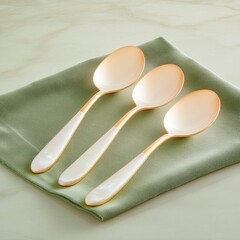 Elegant Gold-Plated Spoons on Soft Green Fabric Background