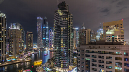 Obraz premium Aerial view of Dubai Marina residential and office skyscrapers with waterfront night timelapse