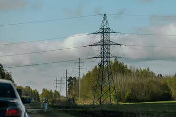 Steel lattice transmission towers supporting high voltage power lines under a bright blue sky with...