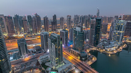 Aerial top view of Dubai Marina night to day timelapse. Modern towers and traffic on the road
