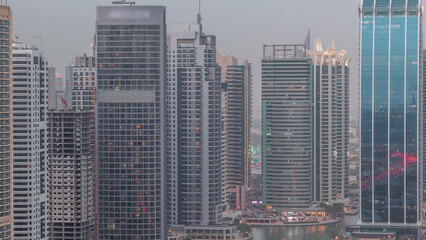 Obraz premium Residential and office buildings in Jumeirah lake towers district day to night timelapse in Dubai