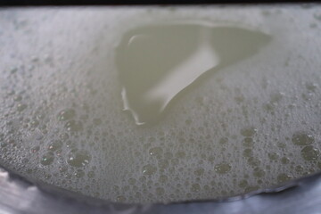 Closeup View of Dense Foamy White Liquid Bubbles with an area of thinner liquid