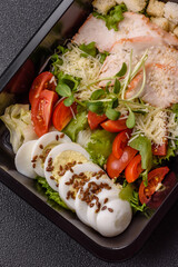 Bowl with caesar salad with chicken, parmesan cheese, tomatoes, croutons, lettuce leaves