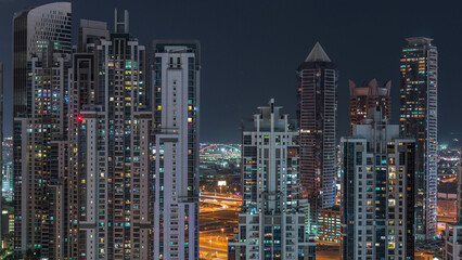 Obraz premium Modern residential and office complex with many towers aerial night timelapse at Business Bay, Dubai, UAE.