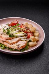 Bowl with caesar salad with chicken, parmesan cheese, tomatoes, croutons, lettuce leaves