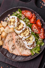 Bowl with caesar salad with chicken, parmesan cheese, tomatoes, croutons, lettuce leaves