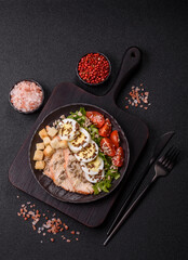 Bowl with caesar salad with chicken, parmesan cheese, tomatoes, croutons, lettuce leaves